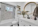 Bright bathroom featuring marble tiled shower, round mirror, and stylish vanity at 3428 Plaza Ln, North Charleston, SC 29420