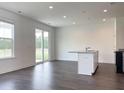 Open living space with wood floors, a modern kitchen island, and a sliding glass door to the backyard at 350 Chapman Cir, Goose Creek, SC 29445