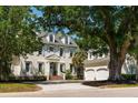 Charming two-story home featuring blue shutters, dormer windows, and a two-car garage, surrounded by lush greenery at 3508 Henrietta Hartford Rd, Mount Pleasant, SC 29466