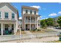 Charming two-story pink home with a white picket fence, offering a cozy and inviting curb appeal at 4631 Scout Aly, North Charleston, SC 29405