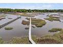 Wide aerial view featuring a marshy coastline and a long wooden pier with docks at 4702 Blockhouse Ln, Hollywood, SC 29449