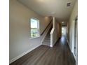 Inviting hallway with wood floors, staircase, and natural light streaming through the window at 5100 Double Eagle, Summerville, SC 29485