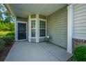 Inviting front porch with a black door, sidelight windows, and neutral colored siding at 626 Battery Edge Dr, Summerville, SC 29486