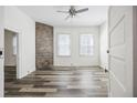 Bright bedroom with modern floors, a brick accent wall, and a ceiling fan at 634 Rutledge Ave, Charleston, SC 29403