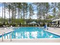 A serene swimming pool offers crystal-clear waters and inviting lounge chairs under the sun at 708 Breakers Reef Ln, Huger, SC 29450