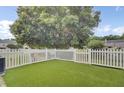 An inviting backyard featuring well-maintained artificial grass, a white picket fence, and a lush green tree offering plenty of shade at 1005 Washitonia Way # B, Charleston, SC 29492