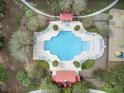 Aerial view of a community pool surrounded by lounge chairs, palm trees, and red-roofed cabanas, offering a luxurious resort-style experience at 1005 Washitonia Way # B, Charleston, SC 29492