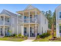 Charming two-story home with double porches, light siding, rocking chairs, and manicured landscaping at 112 Crimson St, Summerville, SC 29486