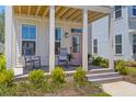 Inviting front porch with rocking chairs and a pink door, creating a cozy curb appeal at 112 Crimson St, Summerville, SC 29486