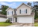 Two-story home with large front windows, a two-car garage, and a well-kept lawn at 125 Towering Pine Dr, Ladson, SC 29456