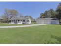 Charming one story home with a welcoming front porch and a large three car garage, set on a green lawn at 1298 French Santee Rd, Jamestown, SC 29453