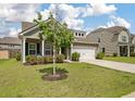 Inviting brick home with a well-maintained lawn, a two-car garage, and shuttered windows at 143 Daniels Creek Cir, Goose Creek, SC 29445
