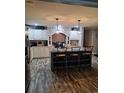 Modern kitchen featuring an island with seating, brick accents, pendant lights, and stainless-steel appliances at 1671 Dawson Branch Rd, Summerville, SC 29483