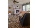 Cozy living room with stone fireplace, wood-look floors, comfortable seating, and bright windows at 1671 Dawson Branch Rd, Summerville, SC 29483