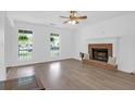 Bright living room with a brick fireplace, hardwood floors, and large windows at 1703 Dotterers Run, Charleston, SC 29414