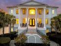 Stately two-story home with grand columns, black trim, and a welcoming front porch with rocking chairs at 1720 Bowline Dr, Mount Pleasant, SC 29466