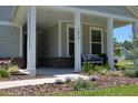 Inviting covered porch with white columns, brick accents, and a cozy bench with seating at 2020 Parish House Cir, Johns Island, SC 29455