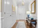 Welcoming hallway with classic wainscoting, wood flooring, and decorative wall accents at 2020 Parish House Cir, Johns Island, SC 29455