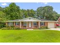 Charming single story brick home featuring a manicured front lawn and covered porch with swing at 2045 Vestry Dr, Charleston, SC 29414
