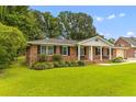 Charming brick home with manicured lawn, covered porch, and attached garage at 2045 Vestry Dr, Charleston, SC 29414