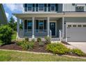 Inviting front porch with flower bed and blue front door with decorative wreath at 214 Center Hill Ct, Summerville, SC 29485