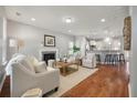 Bright living room featuring a cozy fireplace, wood floors, and an open layout to the kitchen at 214 Center Hill Ct, Summerville, SC 29485