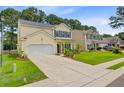 Charming two-story home with yellow siding, black shutters, well-manicured lawn and beautiful landscaping at 230 Sweet Alyssum Dr, Ladson, SC 29456