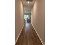 Long hallway with wood floors leads to dining area with natural light at 305 Camellia Bloom Dr, Moncks Corner, SC 29461