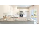 Modern kitchen featuring white cabinets, granite countertops, stainless steel appliances, and sliding glass doors at 317 Salvia Sq, Moncks Corner, SC 29461
