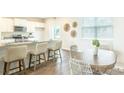 Bright kitchen featuring white cabinets, stainless steel appliances, granite countertops and a wooden dining table at 317 Salvia Sq, Moncks Corner, SC 29461