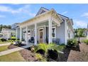 Charming single-story home showing a welcoming covered front porch with nice landscaping and a side entry garage at 3529 Habenaria Rd # 33, Mount Pleasant, SC 29466