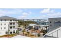 Charming street view featuring well-maintained buildings, palm trees and waterfront bridge in the background at 405 Spartina Ln # 405, Charleston, SC 29492