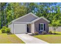 Charming single-story home with a manicured lawn and inviting entrance, showcasing curb appeal at 407 Spruce Ivy St, Moncks Corner, SC 29461