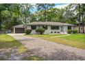 Beautiful home with a white-painted brick exterior, black window shutters, and a gravel driveway at 408 N Palmetto St, Summerville, SC 29483