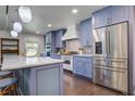 Modern kitchen featuring stainless steel appliances, a large island with a marble countertop, and custom cabinets at 408 N Palmetto St, Summerville, SC 29483
