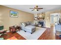Spacious living room featuring hardwood floors, a stone fireplace, a ceiling fan, and neutral decor at 4662 Nibbs Ln, North Charleston, SC 29418