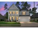 Beautiful two-story home featuring a charming front porch, two car garage, and lovely evening sky at 523 Kilarney Rd, Summerville, SC 29483
