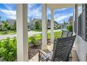 Cozy front porch featuring classic columns, comfortable seating, and a view of the quiet neighborhood at 523 Kilarney Rd, Summerville, SC 29483