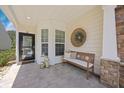 Charming front porch featuring a bench, decorative wreath, and stylish lanterns, perfect for relaxing outdoors at 548 Sea Foam St, Summerville, SC 29486