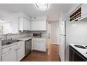 Well-lit kitchen featuring white cabinetry, essential appliances, and wood flooring at 700 Daniel Ellis Dr # 11302, Charleston, SC 29412
