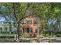 Charming two-story home with wood siding, a covered balcony, and lush landscaping at 82 Ponsbury Rd, Mount Pleasant, SC 29464