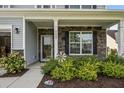 Inviting front porch with stone accents, decorative landscaping, and charming decor at 9009 Chato Ct, Summerville, SC 29483