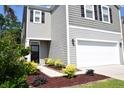 Charming two-story home featuring gray siding, black shutters, a two-car garage, and meticulous landscaping at 9694 Roseberry St, Ladson, SC 29456