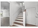 Bright entryway featuring wood stairs with white trim, light walls, and access to an adjacent room at 6 Kirkland Ln, Charleston, SC 29401