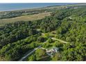 Stunning aerial view showcasing property's expansive land and proximity to marsh and beaches at 1064 Blackbear Dr, Edisto Island, SC 29438