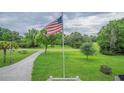 Expansive front yard with the American flag waving proudly, offering a peaceful setting at 1064 Blackbear Dr, Edisto Island, SC 29438