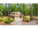 Exterior view of two-story home featuring brick accents, a two-car garage, and a tree-lined yard at 110 Cantering Hills Ln, Summerville, SC 29483