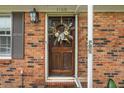 Inviting front door of home featuring number 1160, stylish wreath, sidelight and brick surround at 1160 Landsdowne Dr, Charleston, SC 29412