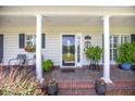 Inviting front porch with brick flooring, decorative plants, and seating area at 127 Travis Hill Rd, Moncks Corner, SC 29461
