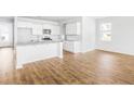 Open concept living space features wood flooring, white cabinets, and lots of natural light at 191 E Pinckney St, Summerville, SC 29485